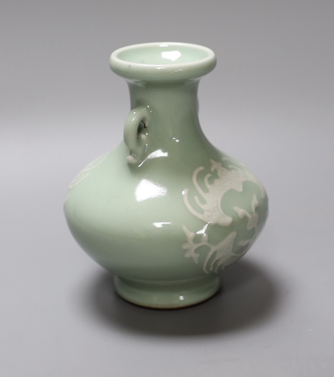 A Chinese celadon two handled vase with slip decoration, 15cm tall